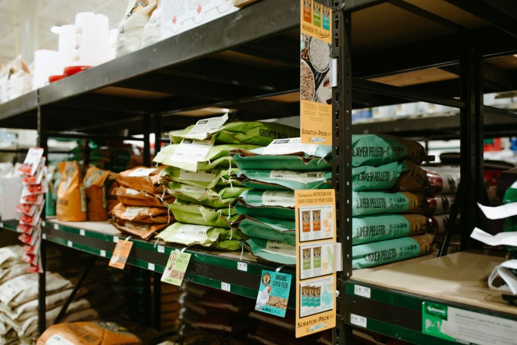 Bags of Scratch and Peck poultry feed on shelf at retail store.